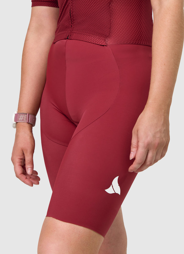 Side angle of TRI-FIT women’s VANGUARD tri-suit in wine red showing ergonomic fit and panel shaping