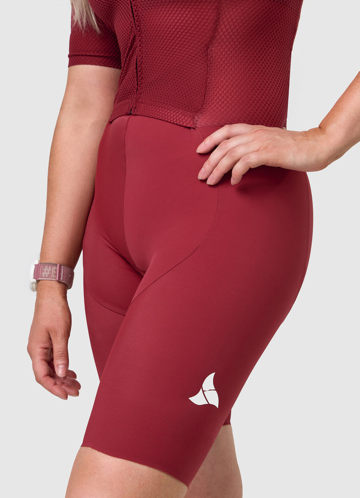 Side angle of TRI-FIT women’s VANGUARD tri-suit in wine red showing ergonomic fit and panel shaping