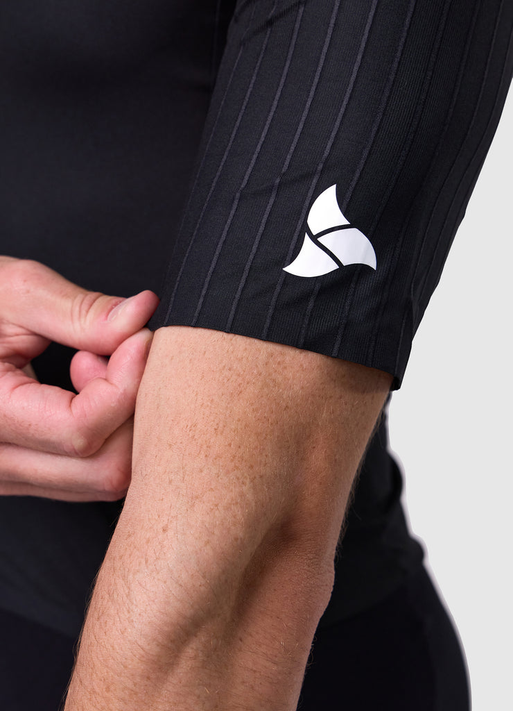 Side view of the men's white/black VORTEX triathlon suit showcasing aero sleeves and race cut