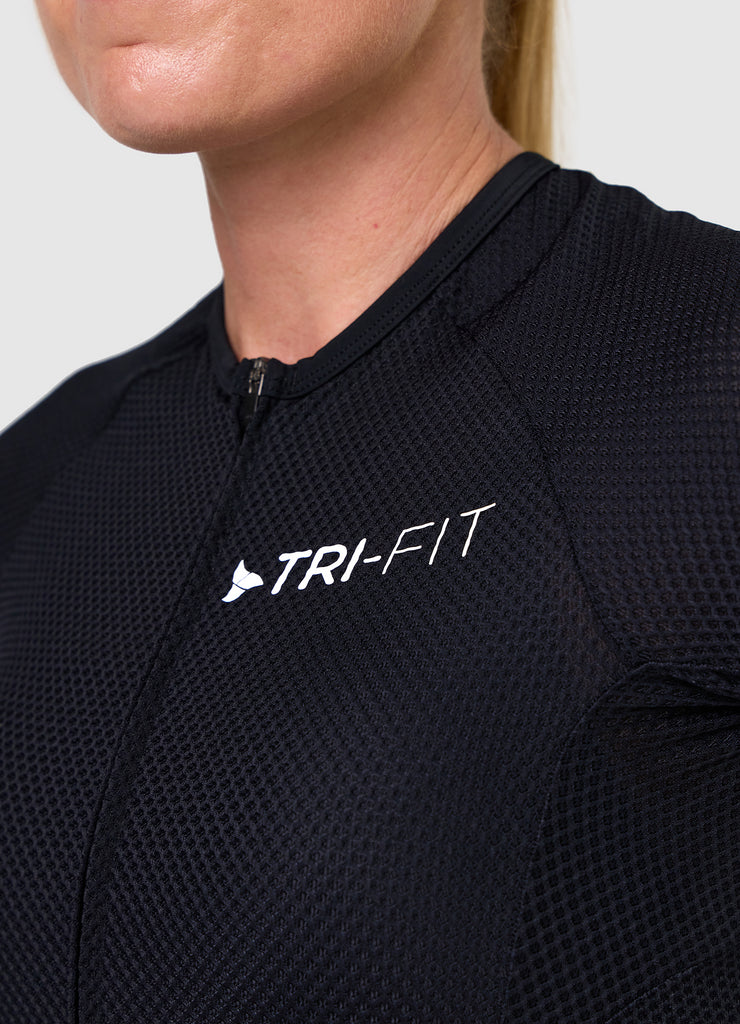 Close-up of TRI-FIT logo printed on the chest of the VANGUARD tri-suit in black, showing textured breathable fabric
