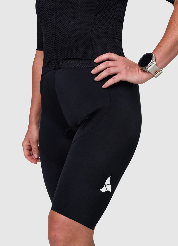 Side angle of TRI-FIT women’s VANGUARD tri-suit in black showing ergonomic fit and panel shaping