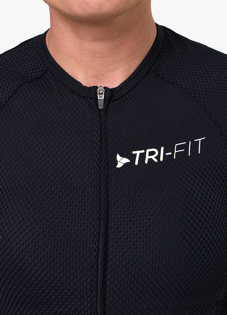 Close-up of TRI-FIT logo printed on the chest of the VANGUARD tri-suit in black, showing textured breathable fabric