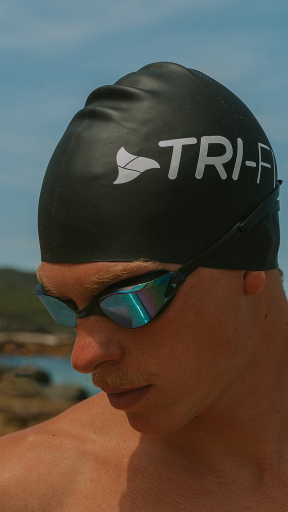 Man wearing TRI-FIT PROPEL Goggles and Black Swim Cap.