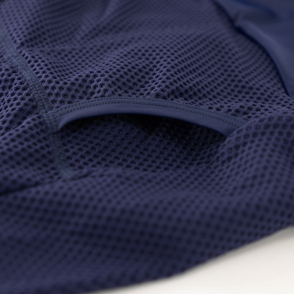 Detail of heat-welded rear pocket entrance on men’s VANGUARD tri-suit in navy, showing reinforced mesh finish